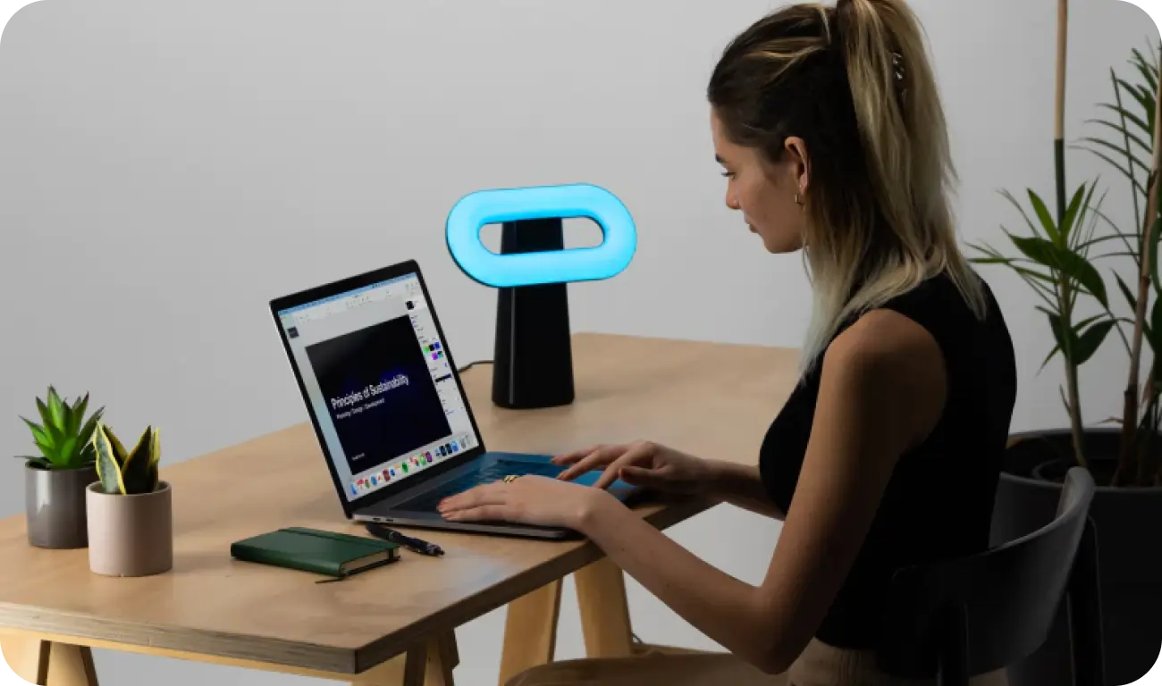 woman working on laptop with Osin lamp on table